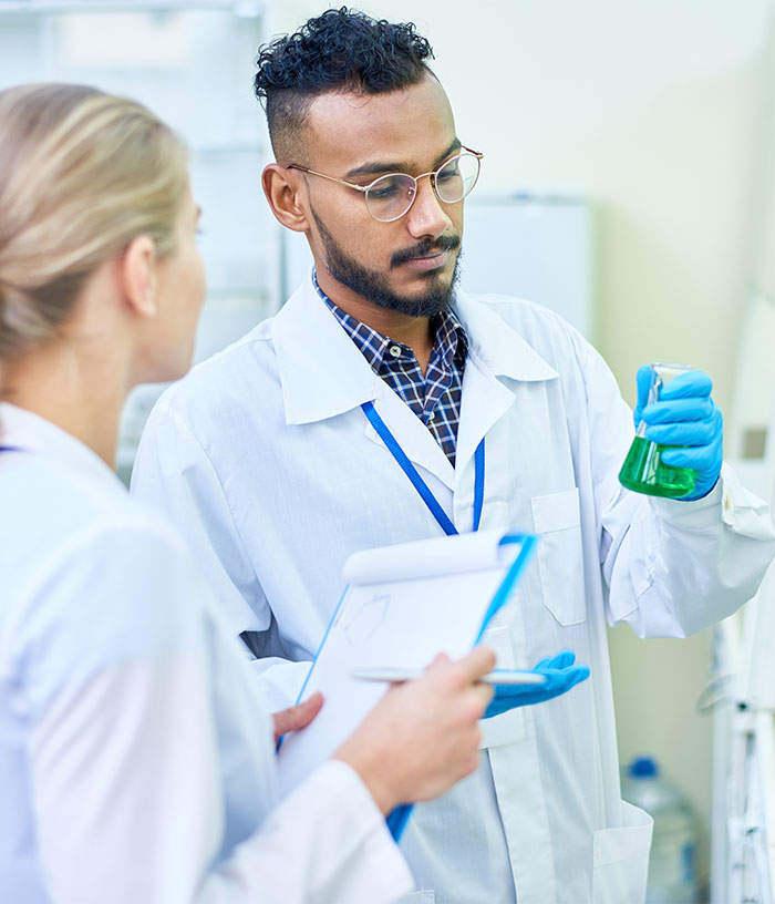 Scientist in ppe suit looking exhausted at camera in lab